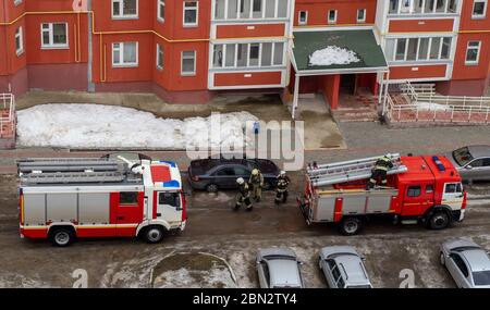 Motore antincendio nel cortile di un edificio residenziale a più piani in inverno. Foto Stock