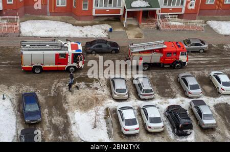 Motore antincendio nel cortile di un edificio residenziale a più piani in inverno. Foto Stock