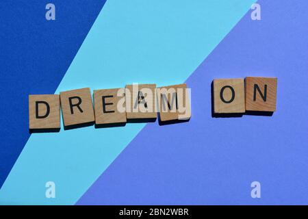Dream on, frase in lettere alfabetiche in legno su uno sfondo viola Foto Stock