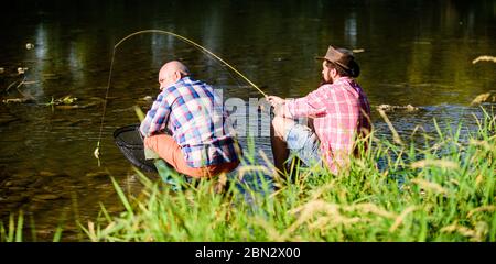 la natura è un luogo di incontro, felice amicizia con i pescatori, pesca di grandi dimensioni. relax. Due amici maschi che pescano insieme. Padre pensionato e figlio maturo sopportato. Pesce mosca hobby di uomini. Pesca di pensione. Foto Stock