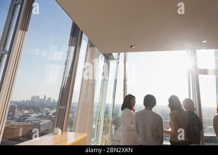 Uomini d'affari che parlano in un moderno ufficio urbano soleggiato Foto Stock