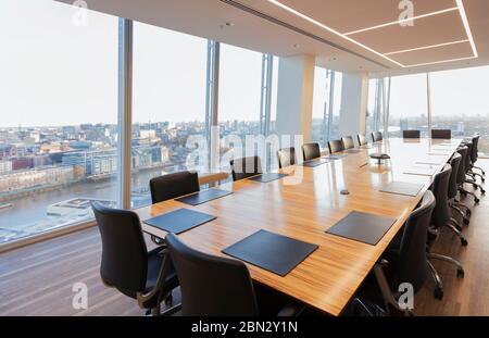 Lungo tavolo da conferenza in un moderno e alto ufficio che si affaccia sulla città Foto Stock