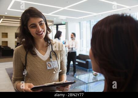 Sorridente dottore che parla con una collega in ufficio Foto Stock