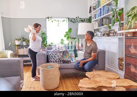 Divertente maturo coppia pieghevole lavanderia in soggiorno Foto Stock