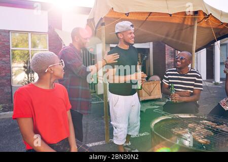 Gli amici si divertono e si godono il barbecue nel parcheggio soleggiato Foto Stock