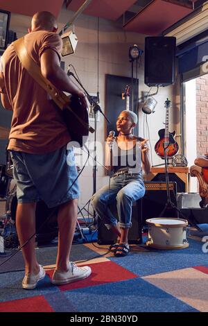 Musicisti che praticano in studio di registrazione Foto Stock