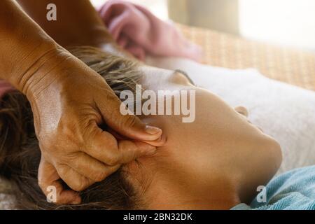 Donna durante il massaggio dell'orecchio Foto Stock