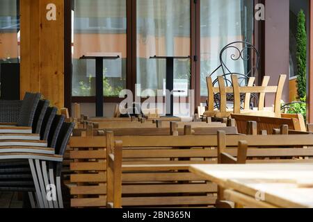 I ristoranti italiani di Merano, in Alto Adige, sono ancora chiusi a causa del COVID-19. Sedie e tavoli impilati e incatenati insieme. Foto Stock