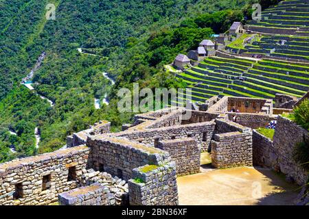 Case di pietra tetti mancanti e terrazze agricole presso l'antica città Inca di Machu Picchu, Valle Sacra, Perù Foto Stock