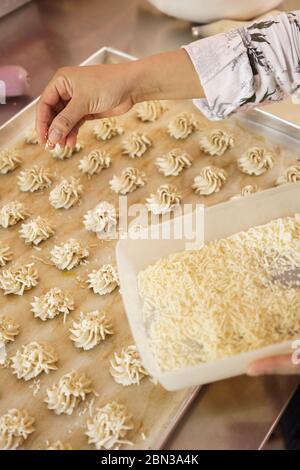 mettere a mano un formaggio a guarnire su una torta. semprit tradizionale torta. kue semperit Foto Stock