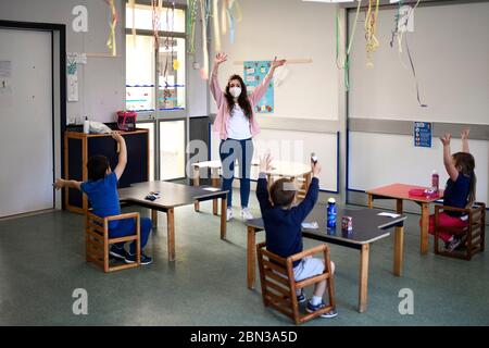 Borgosesia, Italia. 12 maggio 2020. BORGOSESIA, ITALIA - 12 maggio 2020: Un educatore gioca con i bambini dell'asilo in una scuola materna, nell'ambito di un test pilota per vedere come le scuole possono riaprire dopo l'avvallamento del coronavirus COVID-19 nella regione Piemonte, proposto dal sindaco di Borgosesia (Vercelli) Paolo Tiramani. (Foto di Nicolò campo/Sipa USA) Credit: Sipa USA/Alamy Live News Foto Stock