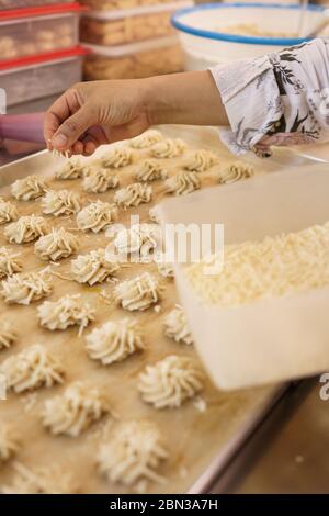 mettere a mano un formaggio a guarnire su una torta. semprit tradizionale torta. kue semperit Foto Stock