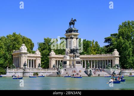 Persone a remi barche sul Lago del Parco Retiro a Madrid, Spagna Foto Stock