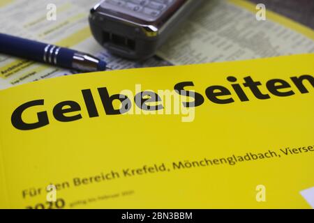 Viersen, Germania - Maggio 9. 2020: Primo piano del libro cartaceo dell'elenco telefonico giallo tedesco isolato (Gelbe Seiten) Foto Stock