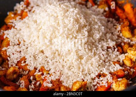 Pilaf Uzbeco nazionale con carne, riso, carote, cipolle, aglio e spezie. Il processo di cottura di cibo Foto Stock