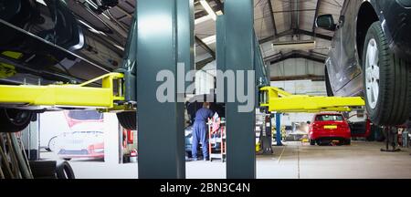 Meccanico maschile che lavora in officina di riparazione auto Foto Stock