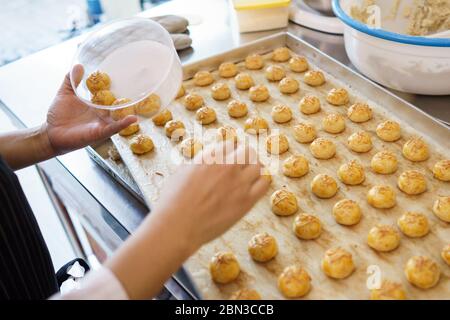 mano mettere torta di nastar su un contenitore. torta di ananas da forno fatta in casa Foto Stock