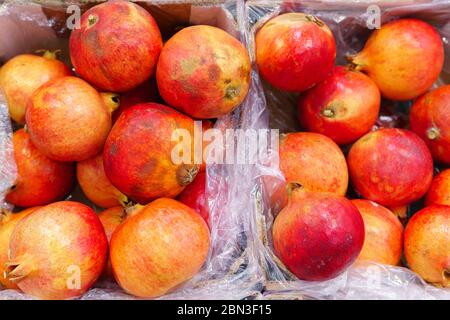 Frutta di melograno rosso nel mercato di strada. Un gruppo di melograni. Texture fuoco selettivo Foto Stock