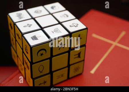 Bibbia e cubo di Rubik con simboli religiosi. Concetto di dialogo interreligioso e interreligioso. Foto Stock