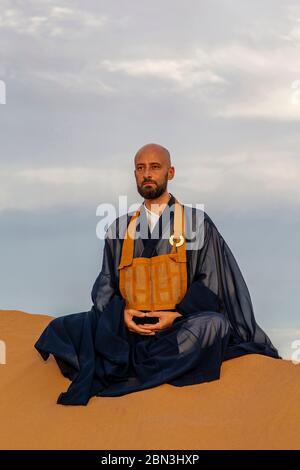 Zen sesshin (ritiro) nel deserto del Sahara, Marocco. Maestro Zen praticando zazen (meditazione). Foto Stock