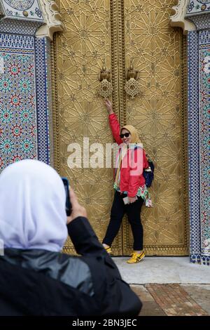 Turista asiatico posa per le foto di fronte alla porta del Palazzo reale, Fes, Marocco. Foto Stock