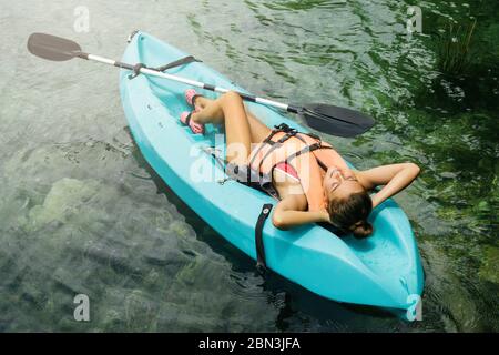 Felice donna rilassarsi durante la sdraiata in kayak Foto Stock