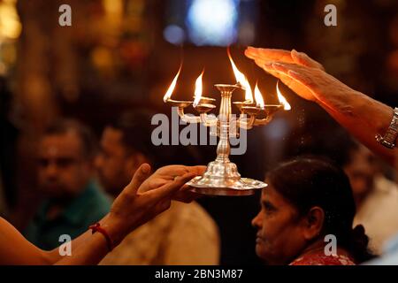 Court Hill Tempio di Ganesh. Prete indù che fa culto alla puja. Prendere la fiamma sacra. Kuala Lumpur. Malesia. Foto Stock