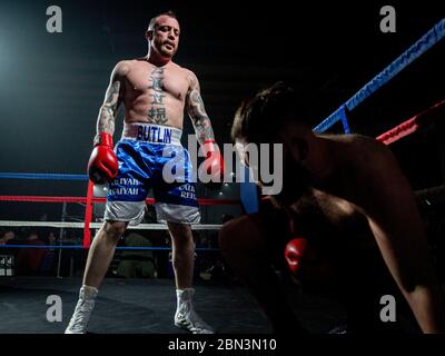 MANCHESTER, REGNO UNITO. 07 Dec 2018. Ian Butlin guarda il suo avversario dopo un colpo di corpo riuscito in corrispondenza 12 di KO Promozioni Christmas Cracker boxing e. Foto Stock