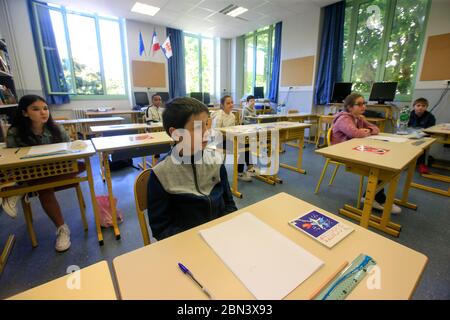 (200512) -- NIZZA, 12 maggio 2020 (Xinhua) -- gli studenti frequentano una classe alla scuola elementare Simone Veil a Nizza, Francia, 12 maggio 2020. Quasi due mesi dopo aver ordinato ai suoi 67 milioni di abitanti di rimanere a casa per arginare l’epidemia di coronavirus, lunedì la Francia ha iniziato con cautela un processo graduale per tornare alla normalità, allentando alcune restrizioni e mantenendo altre per evitare una nuova ondata epidemica. Circa 1.5 milioni di bambini, ovvero il 22% del numero totale di studenti del paese, si stanno preparando a frequentare la scuola il martedì, e 190,000 insegnanti hanno ripreso il lavoro il lunedì, secondo il min Foto Stock