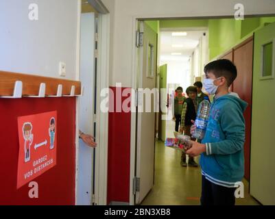 (200512) -- NIZZA, 12 maggio 2020 (Xinhua) -- gli scolari che indossano maschere facciali si allineano quando entrano in classe alla scuola primaria Simone Veil di Nizza, Francia, 12 maggio 2020. Quasi due mesi dopo aver ordinato ai suoi 67 milioni di abitanti di rimanere a casa per arginare l’epidemia di coronavirus, lunedì la Francia ha iniziato con cautela un processo graduale per tornare alla normalità, allentando alcune restrizioni e mantenendo altre per evitare una nuova ondata epidemica. Circa 1. Credit: Xinhua/Alamy Live News Foto Stock