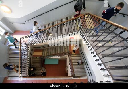 (200512) -- NIZZA, 12 maggio 2020 (Xinhua) -- gli scolari che indossano maschere facciali mantengono le distanze sociali come entrano nella scuola primaria Simone Veil a Nizza, Francia, 12 maggio 2020. Quasi due mesi dopo aver ordinato ai suoi 67 milioni di abitanti di rimanere a casa per arginare l’epidemia di coronavirus, lunedì la Francia ha iniziato con cautela un processo graduale per tornare alla normalità, allentando alcune restrizioni e mantenendo altre per evitare una nuova ondata epidemica. Circa 1. Credit: Xinhua/Alamy Live News Foto Stock