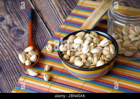 pistacchi salati in un vaso su un panno da tavola. Foto Stock