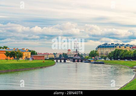 Canale sullo stretto di Kronverksky tra Zayachy Hare e l'isola di Petrogradsky con il ponte di Kronverk, avena e nave di legno, sfondo blu drammatico del cielo, città di San Pietroburgo Leningrado, Russia Foto Stock