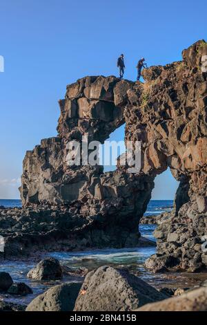 Mauritius, 2009 giugno - due uomini che camminano su una formazione rocciosa sulla costa di Pointe aux Caves, Albion, Mauritius Foto Stock