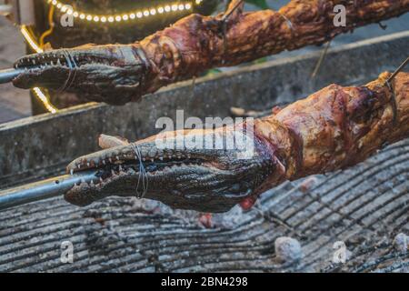 Coccodrillo alla griglia sul fuoco aperto al ristorante di pesce, pasti esotici a Viethnam, cibo della cucina asiatica, carne di coccodrillo crudo, cibo esotico. Foto Stock
