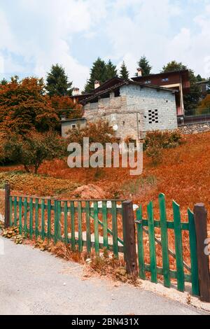 Paesaggio alpino in autunno, vecchio fienile dietro una recinzione di legno Foto Stock