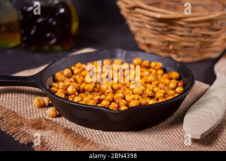 Ceci speziati arrostiti in una padella di metallo nero. Cibo sano e vegetariano Foto Stock