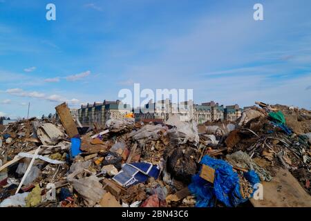 Sito di discarica illegale vicino a edifici residenziali nella regione di Mosca, Russia. Le autorità locali lottano per attuare politiche di gestione dei rifiuti di materiale MODer. Foto Stock