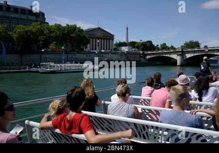 I turisti sul fiume Bateaux-Mouches crociera in barca Senna con il ponte Pont de la Concorde, l'Assemblea Nazionale e la Torre Eiffel sullo sfondo.Paris.France Foto Stock
