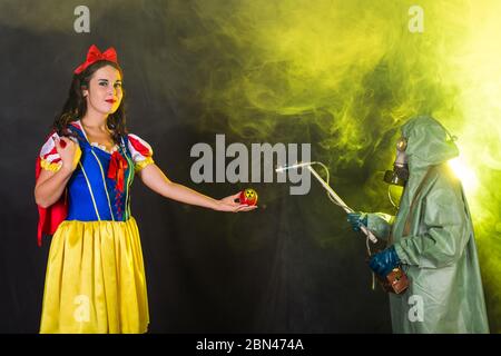 Donna in possesso di mela radioattiva pericolosa. Concetto di misurazione nucleare e di radiazione. Foto Stock