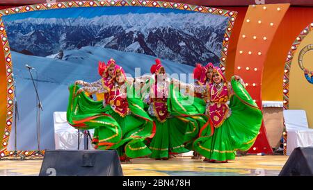 Giovani danzatori indiani maschili e femminili che eseguono danza regionale/folk in abiti colorati Foto Stock