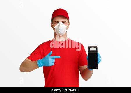 Corriere in uniforme rossa, maschera protettiva e guanto, punta il dito sul terminale senza contatto. Foto Stock