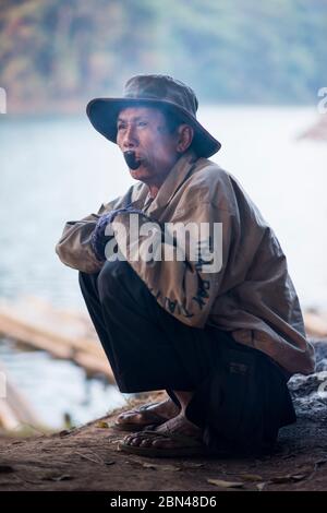 Il conducente locale di zattera di bambù fuma una pipa mentre aspetta i clienti al Pang Ung, Mae Hong Son, Thailandia. Foto Stock