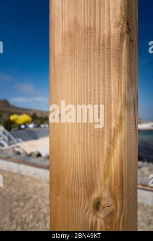 Tavola di legno su una verticale contro uno sfondo spiaggia, luogo per l'iscrizione copyspace, texture legno, per la pubblicità puntatore. Foto Stock