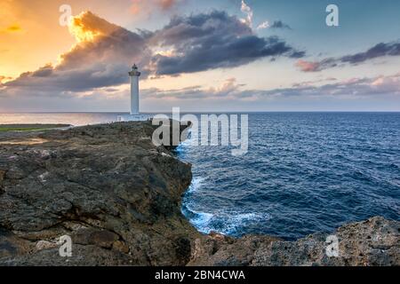 Bellissimo tramonto a Capo Zanpa con faro di Zanpa sulla scogliera sopra l'oceano, isola di Okinawa in Giappone Foto Stock