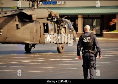 Un ufficiale del CBP assiste la North Carolina Army Air National Guard nell'assicurare un atterraggio di emergenza in un centro commerciale pubblico a Wilmington, NC durante le operazioni di risposta all'uragano Florence. Foto Stock