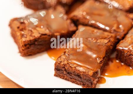 Primo piano su pezzi di brownie con salsa al caramello salato Foto Stock