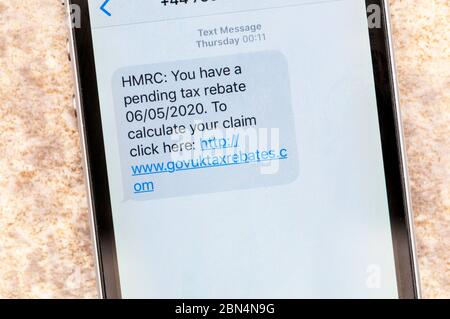 Un messaggio di truffa visualizzato su un iphone che finge di provenire da HMRC con un rimborso fiscale in sospeso. Foto Stock