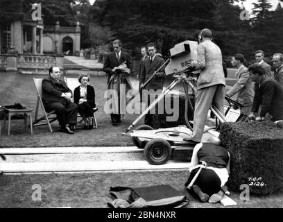 ALFRED HITCHCOCK e NOVA PILBEAM regista e star di GIOVANI E INNOCENTI intervistati da LESLIE MITCHELL il 5 ottobre 1937 a Gardens of PINEWOOD STUDIOS per serie TV IL FILM STUDIOS prodotto da British Broadcasting Corporation (BBC) Foto Stock