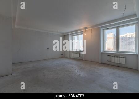Nuovo studio interno loft in casa vuota. Due finestre, pareti in cemento Foto Stock